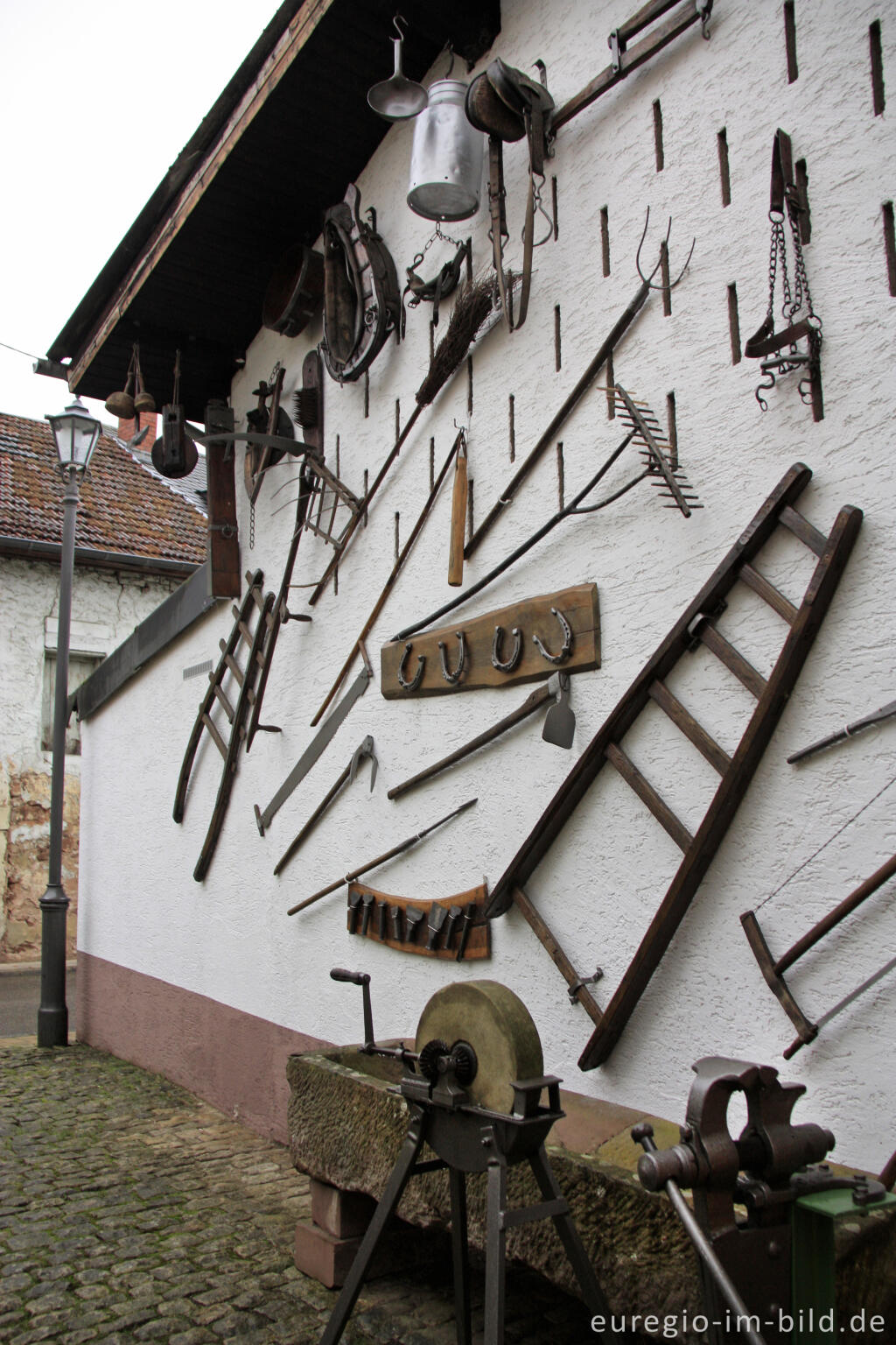 Detailansicht von Alte Werkzeuge an einer Hauswand in Kordel, Südeifel