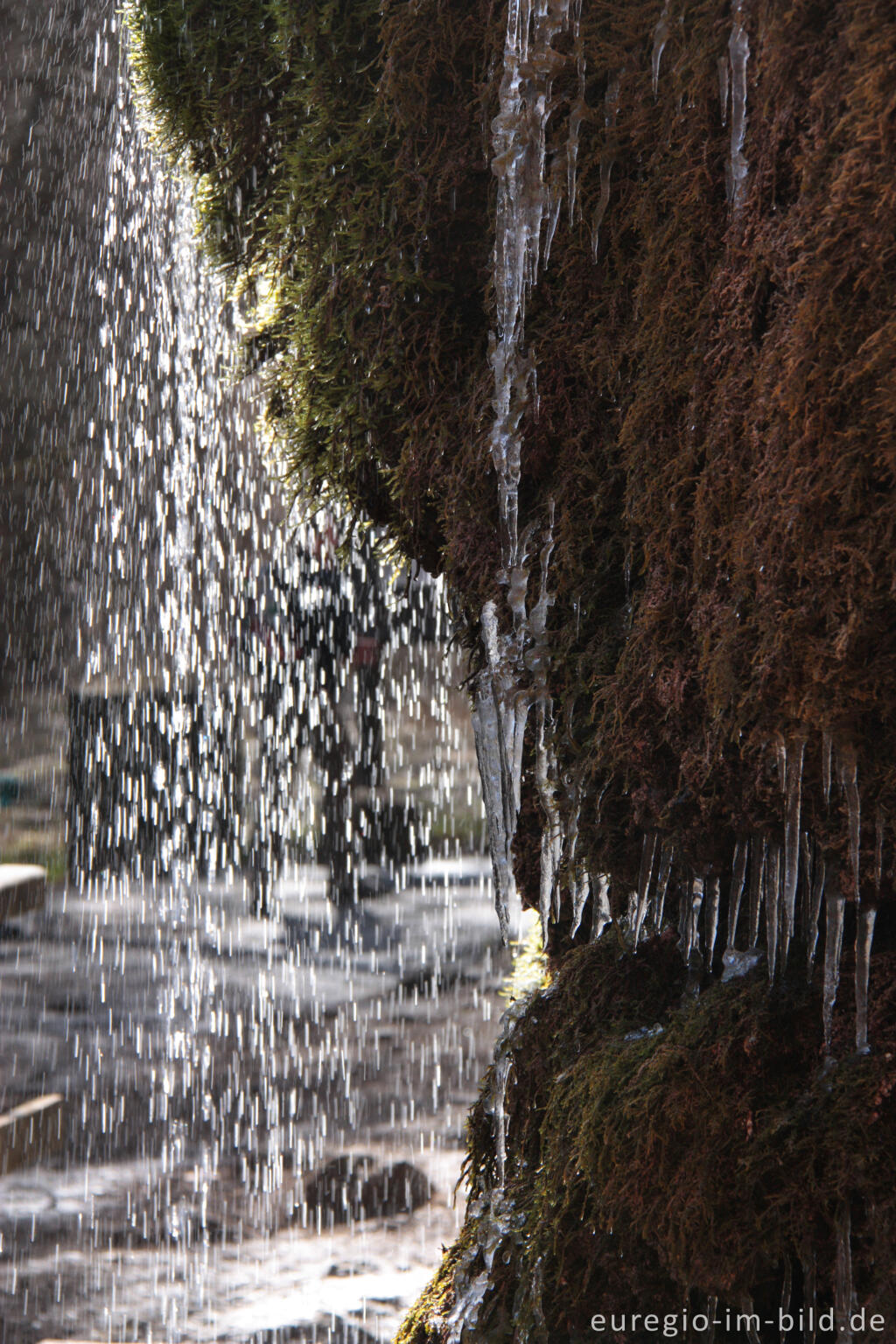 Detailansicht von Wasservorhang und Eiszapfen beim Dreimühlen-Wasserfall