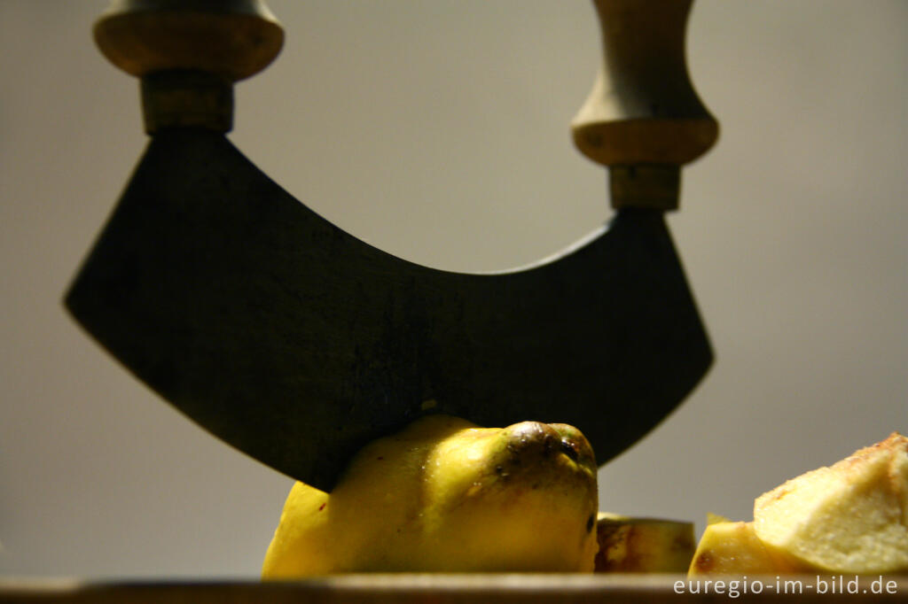 Detailansicht von Zerkleinern von Quitten mit einem Wiegemesser