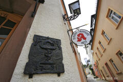 Takenplatte mit dem Symbol der Äskulapnatter vor der Schloss-Apotheke, Neuerburg