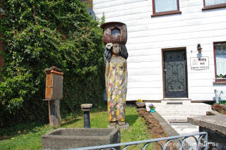 Vorgarten in Neroth mit Holzskulptur